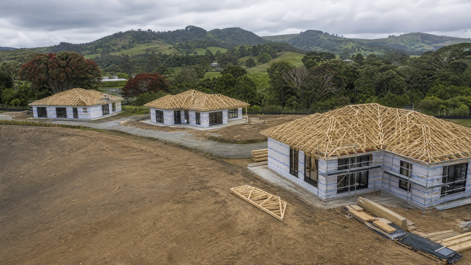 New Northland homes under construction among green hills