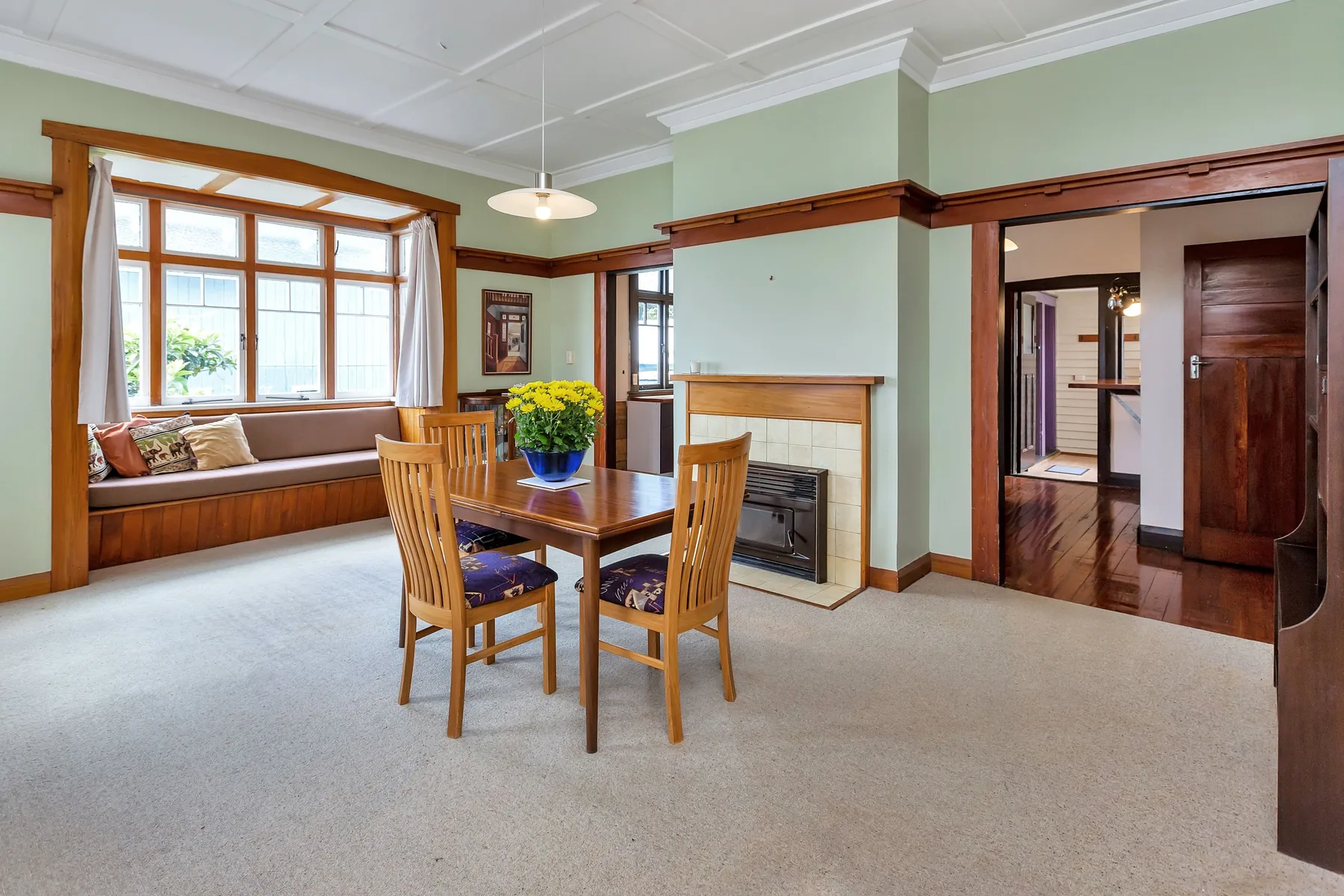 Former dining room with timber bay window, fireplace and pale carpet