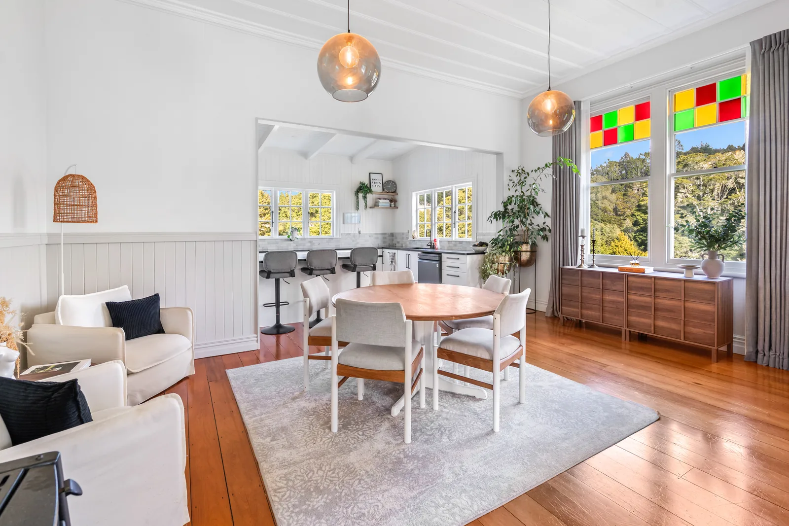 Renovated villa interior with stained-glass window, dining space and timber flooring