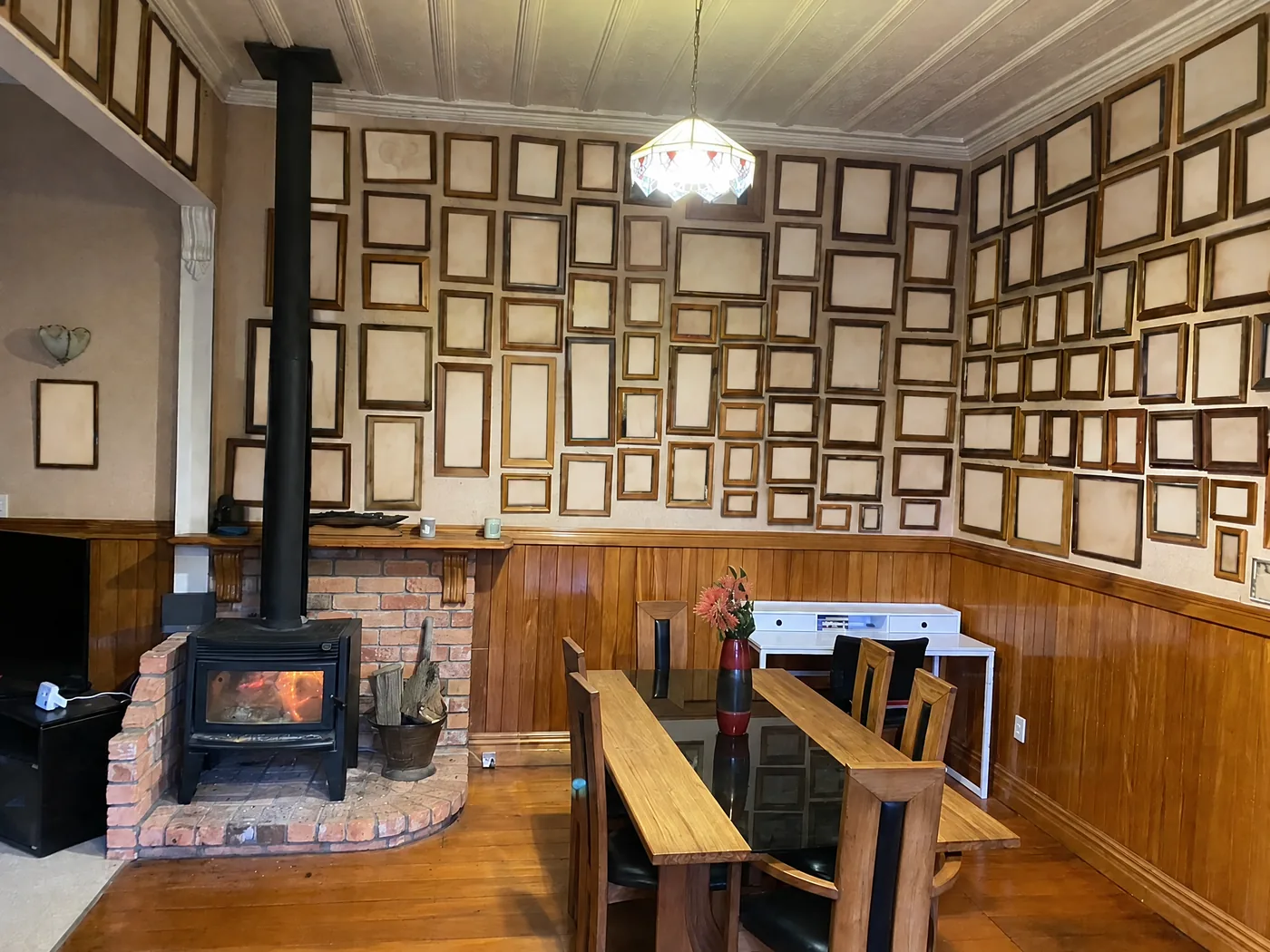 Living and dining room before renovation, with framed personal photographs blanked