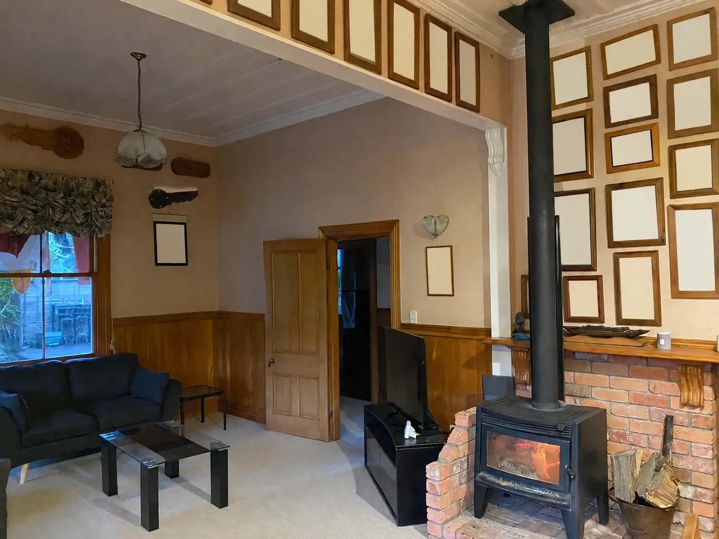 Villa living room before renovation, with framed personal photographs blanked