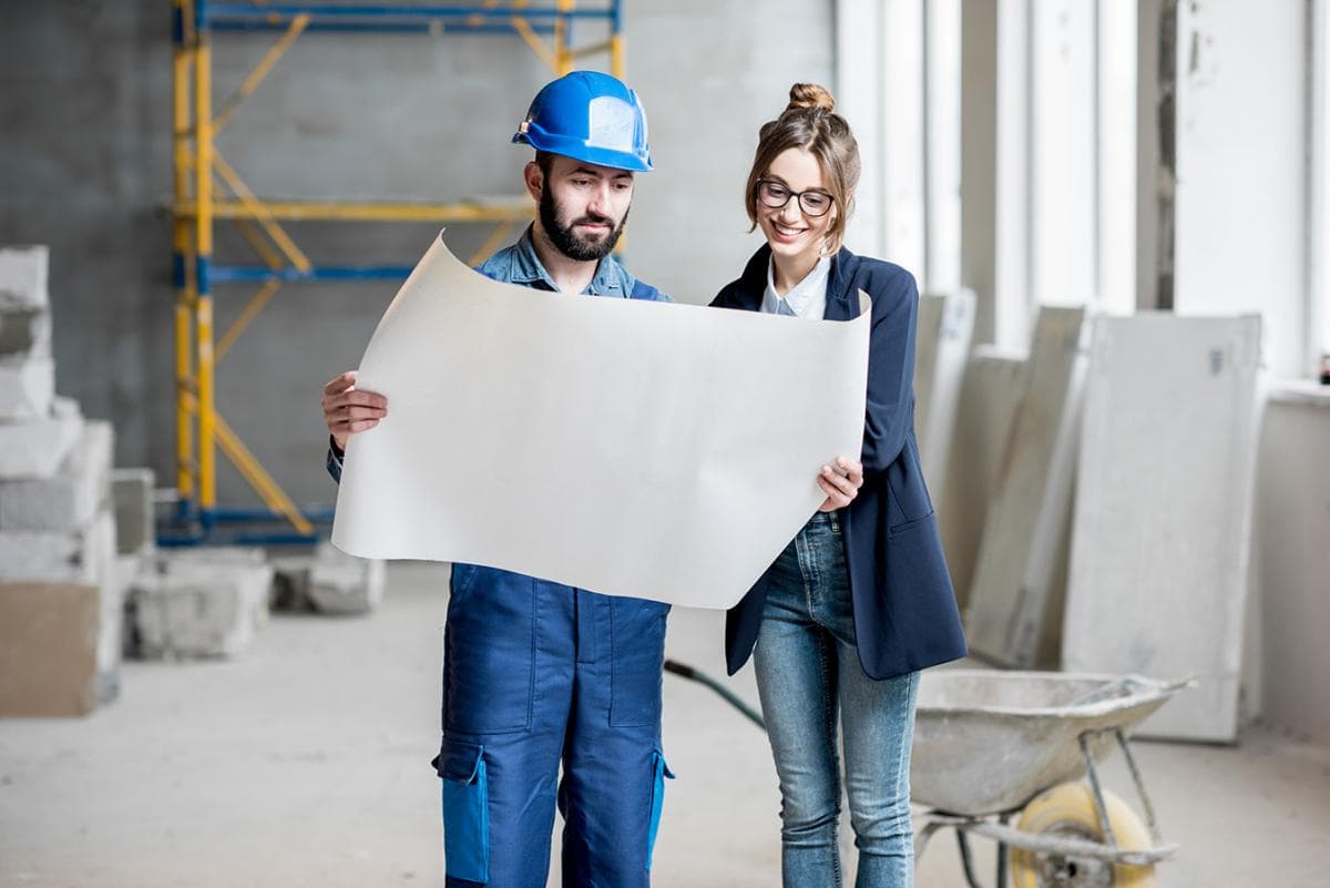 Construction team reviewing building plans and project timeline on site